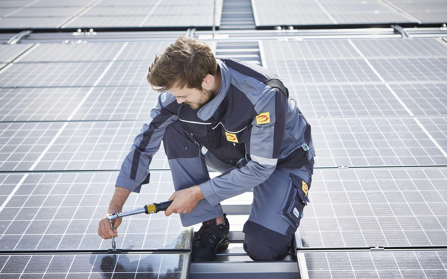 E-CHECK E-Mobilität - Mitarbeiter montiert auf dem Dach die neuen Solarmodule &middot; Elektro Busch GmbH
